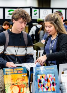 Two PASIC percussionists look at sheet music for sale.